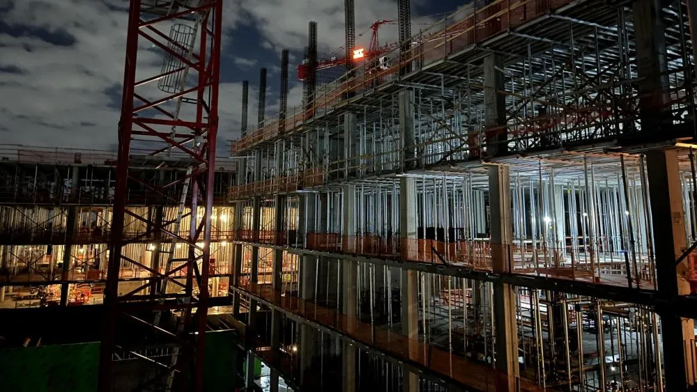 An April 2023 contest winner features the Aggie Square construction site at night. A bright orange light on the crane shines with the logo of the contractors, Whiting-Turner. Photo by Craig Casity.