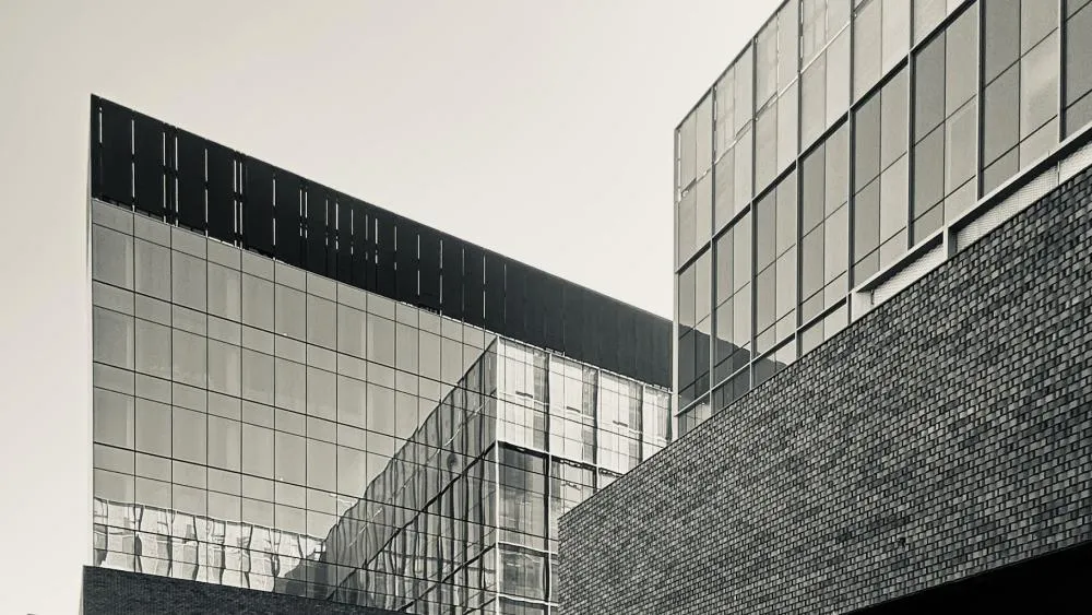 The first place photo for August 2024 captures a cinematic black and white still of the Aggie Square buildings. Photo by Ryan Robinett.