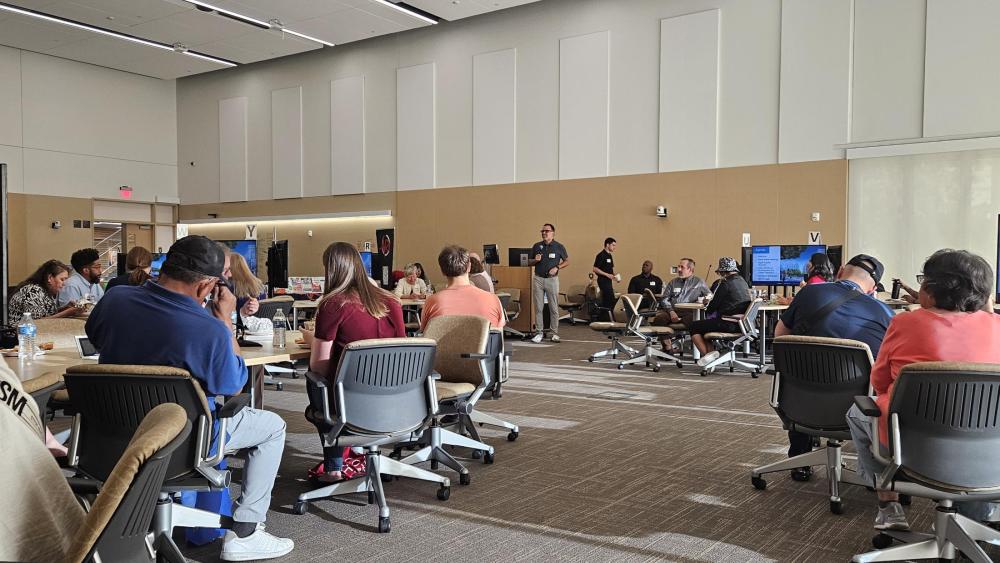 Travis Sheridan, the Senior Vice President and Chief Community Officer at Wexford, presented the agenda for the Aggie Square community meeting.