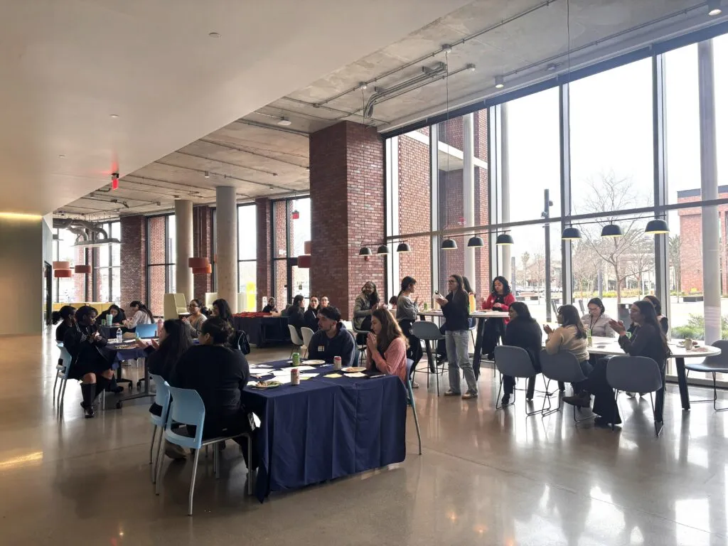 women sitting at tables discussing and eating
